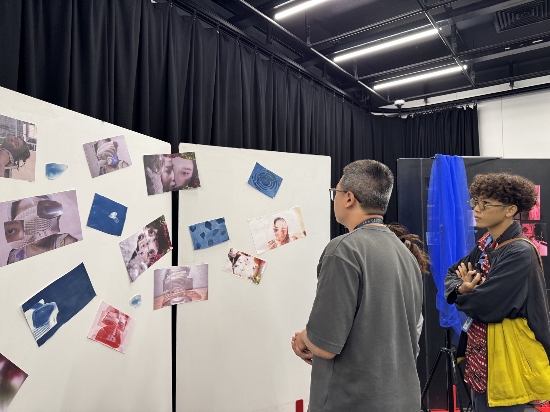 Visitors looking at blue cyanotype prints on white display boards