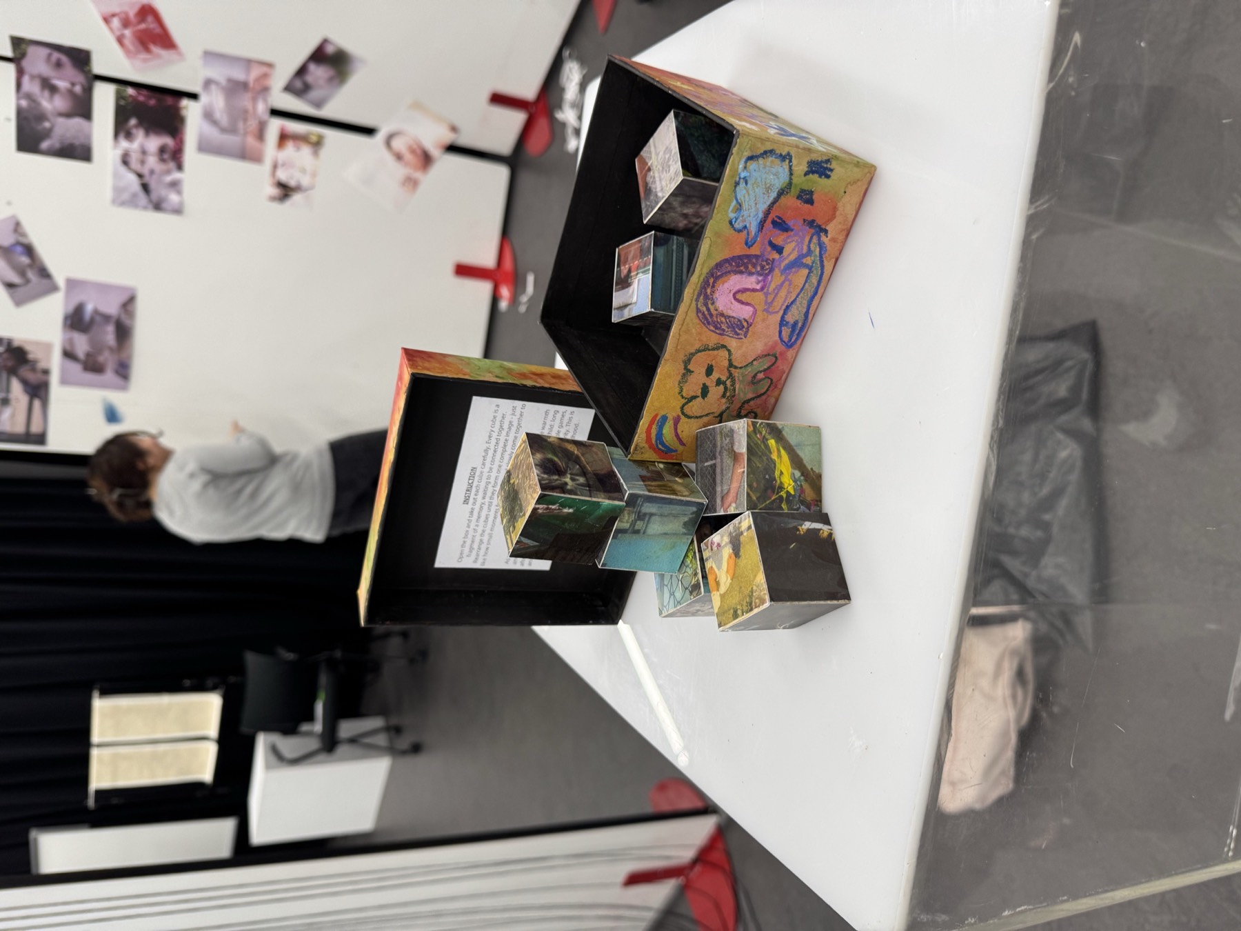 A black shelf installation holding framed colour works