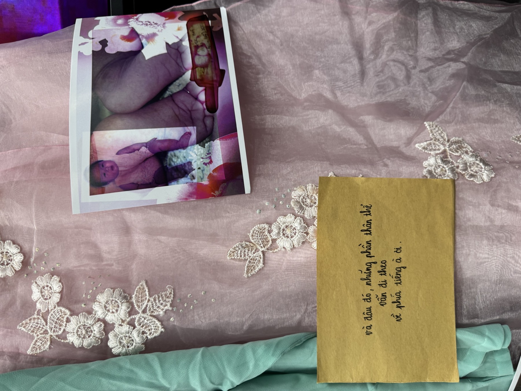 A pink fabric installation with a zine and printed text